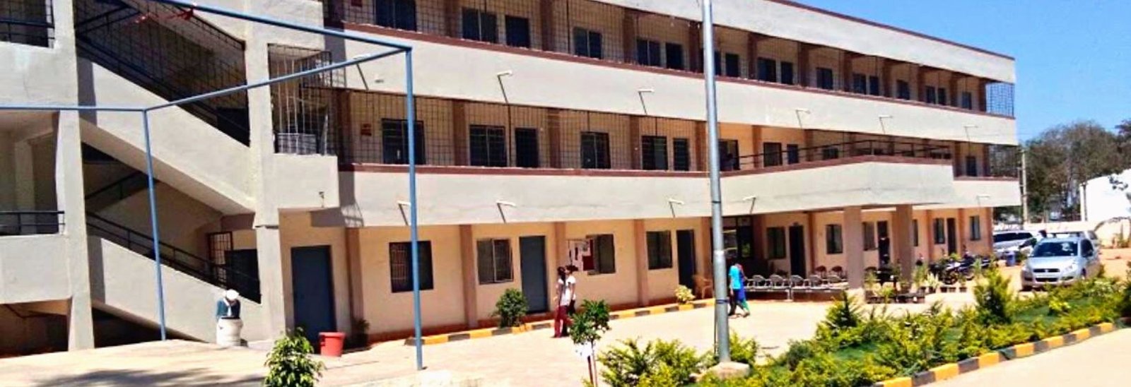 An image of the Rural College of Nursing Koppal, showing the main building and surrounding campus.