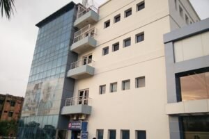 A modern building with the Sarvodaya College of Nursing logo, surrounded by greenery.